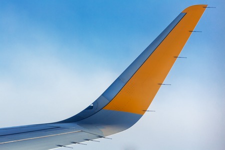 Airplane wing detail on blue sky backgroundの写真素材