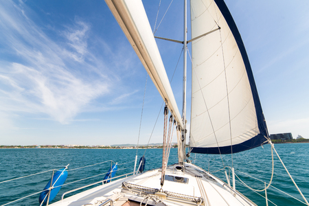 Yatch sail and desk on blue sky and sea backgroundの写真素材