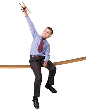 boy in a suit playing with plane modelの写真素材