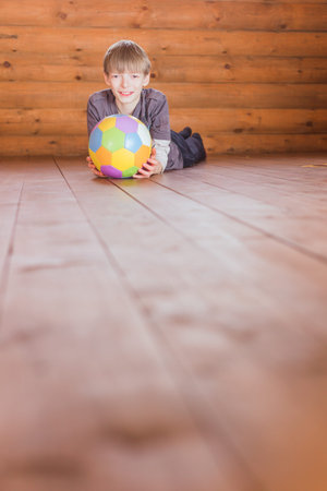 Boy with a ball in wooden interiorの写真素材