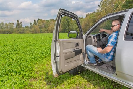 Man sitting in a car on driver's place and looking forwardの写真素材