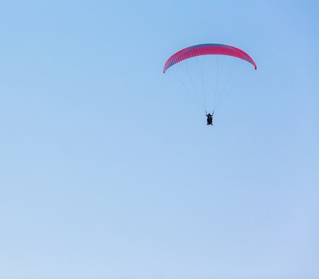 Some people parasailing over the sea on blue sky backgroundの写真素材