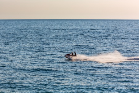 People riding jet ski on sea backgroundの写真素材