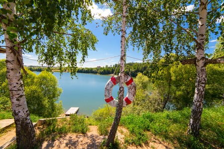 Lifebuoy on the pond beach at good sunny dayの写真素材