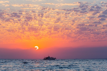 Colorful sunset over the sea with beautiful sky and cruise boat silhouetteの写真素材