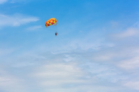 Some people parasailing over the sea on blue sky backgroundの写真素材