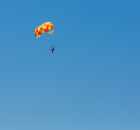 People parasailing over the sea on blue sky backgroundの写真素材
