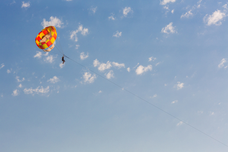 People parasailing over the sea on blue sky backgroundの写真素材