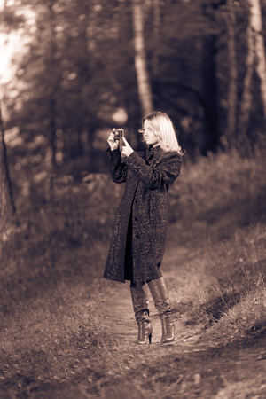 Woman walking in the park with old fashion cameraの写真素材