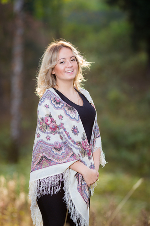 Young pretty woman at traditional shawl in the  summer parkの写真素材