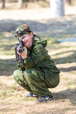 Boy with a gun playing lazer tag open airの写真素材
