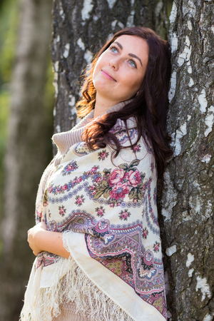 Long hair woman at traditional shawl near the birch tree.の写真素材