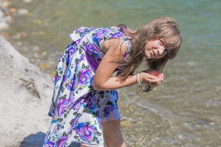 Cute preteen long hair girl posing on riverbankの写真素材