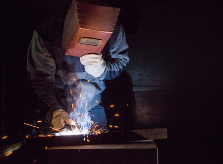 Welder working in a factory welding the metal