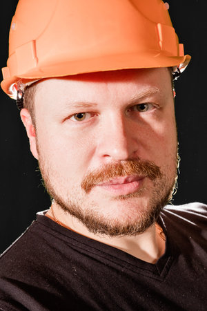 Handsome worker in safety helmet portrait low keyの写真素材