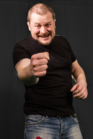 Agressive bully threatens with a fist portrait low keyの写真素材