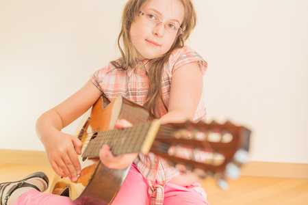 Girl sitting on floor with russian seven-string acoustic guitarの写真素材