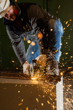 Worker working of a grinding machine with a lot of sparks