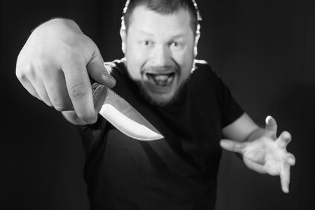 Portrait of a gangster with a knife low key