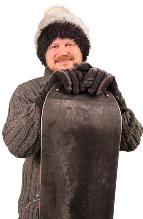 Man in sweater standing with snowboard on white backgroundの写真素材