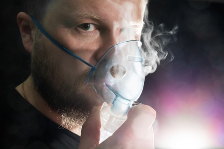 Man breathing through nebulizer maskの写真素材