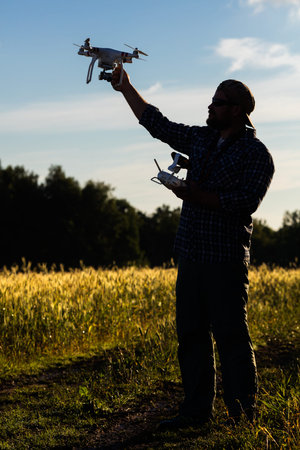 Operator holding drone and controller in his arms