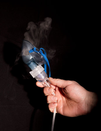 Man holding nebulizer mask with vapour