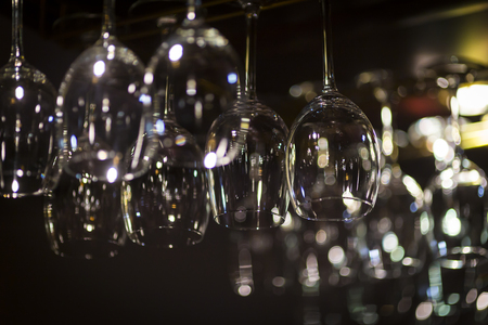 Vine glasses hanged on bar rackの写真素材