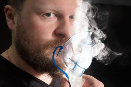 Man breathing through nebulizer maskの写真素材