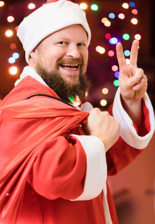 Bearded man dressed in Santa Claus costume with gifts studio portraitの写真素材