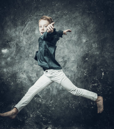 Young figure skater dressed in white jeans and blue shirt