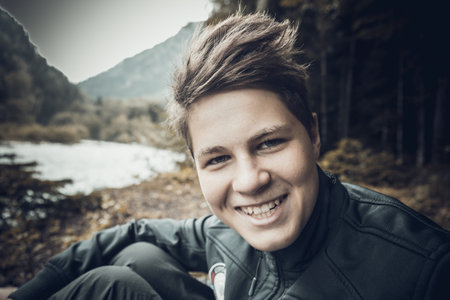 Teen boy traveler portrait with river in Caucasus mountains.