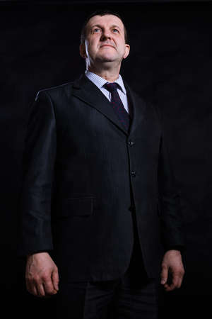 Middle aged solid man dressed in suit studio portraitの写真素材