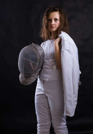 Teenage girl fencer dressed in uniform with epee and helmetの写真素材