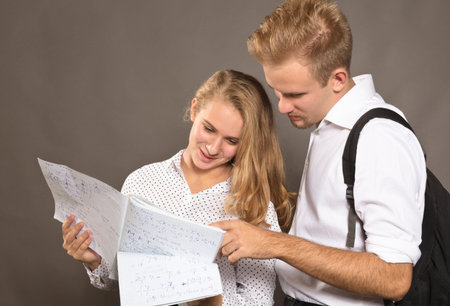 Two students young man and woman watching papers