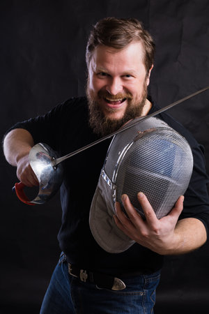 Middle aged bearded man with epee and helmet