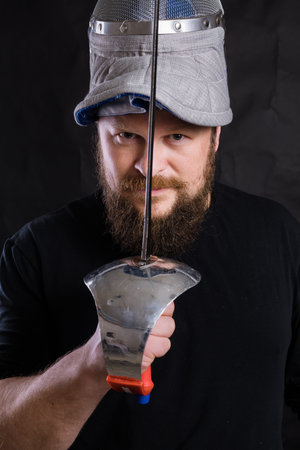 Middle aged bearded man with epee and helmet