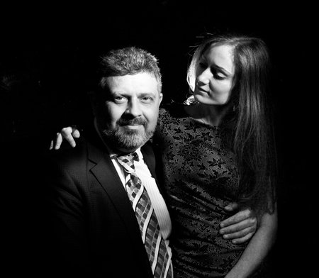 Bearded man and young woman, happy couple studio portrait.