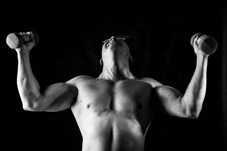 Matured man with naked muscular torso making exercisesの写真素材