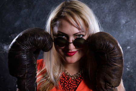 Attractive plump woman with boxing gloves studio portrait.