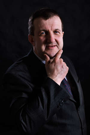 Middle aged solid man dressed in suit studio portraitの写真素材