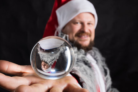 Cheerful Santa dressed in fur skin with crystal spehreの写真素材