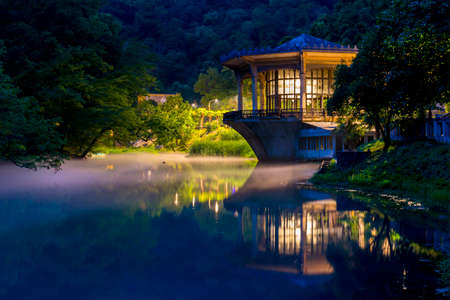 Beautiful night landscape with old pavilion on the waterの写真素材