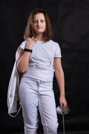 Teenage girl fencer dressed in uniform with epee and helmetの写真素材