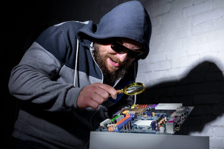 Bearded hacker in sunglasses and hoodie cracking the hardware