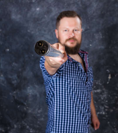 Solid bearded man at casual clothes with a fluorescent lamp looks like stickの写真素材