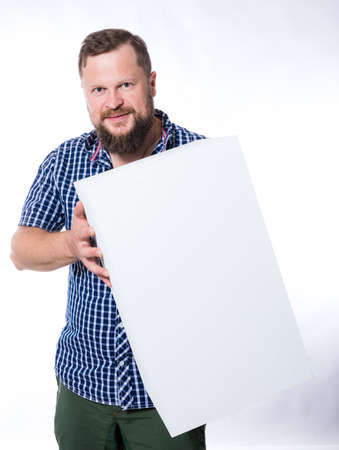 Joyful bearded man in shirt with blanc object for your logoの写真素材
