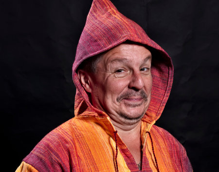 Middle aged man in bright orange clothe smiling
