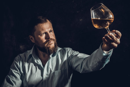 Solid bearded man in shirt with glass of whisky