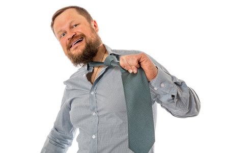 Cheerful bearded man dressed in shirt rips off his tie